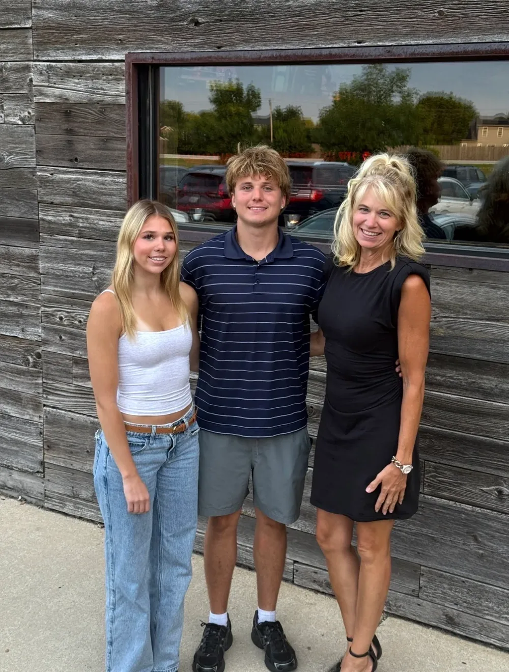 Kristin standing outdoors with two members of her family